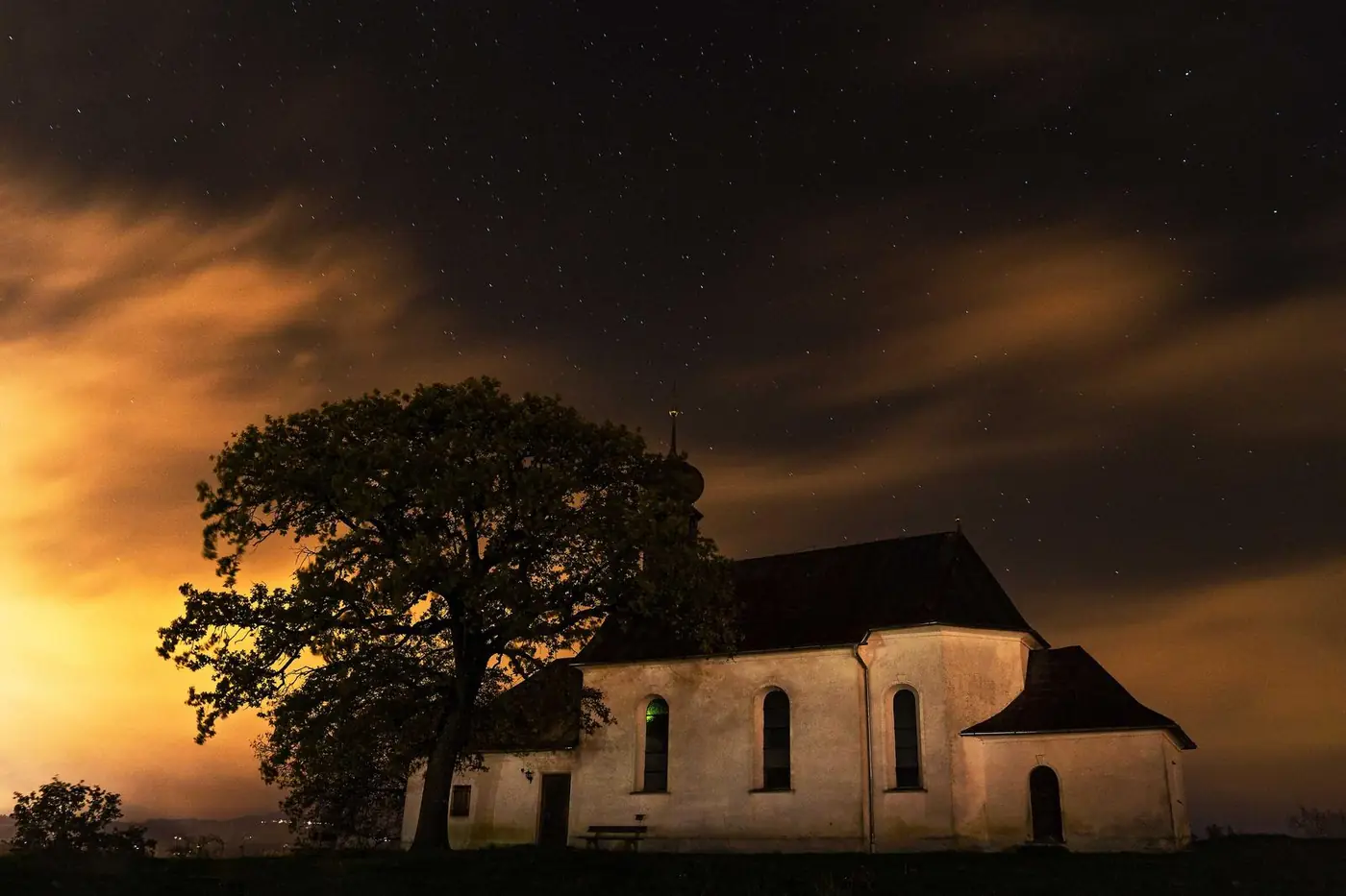 Church silhouette against an orange sunset sky