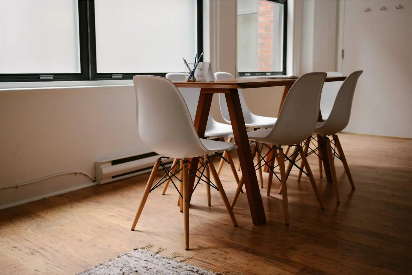 Bright meeting room with a wooden table and white chairs