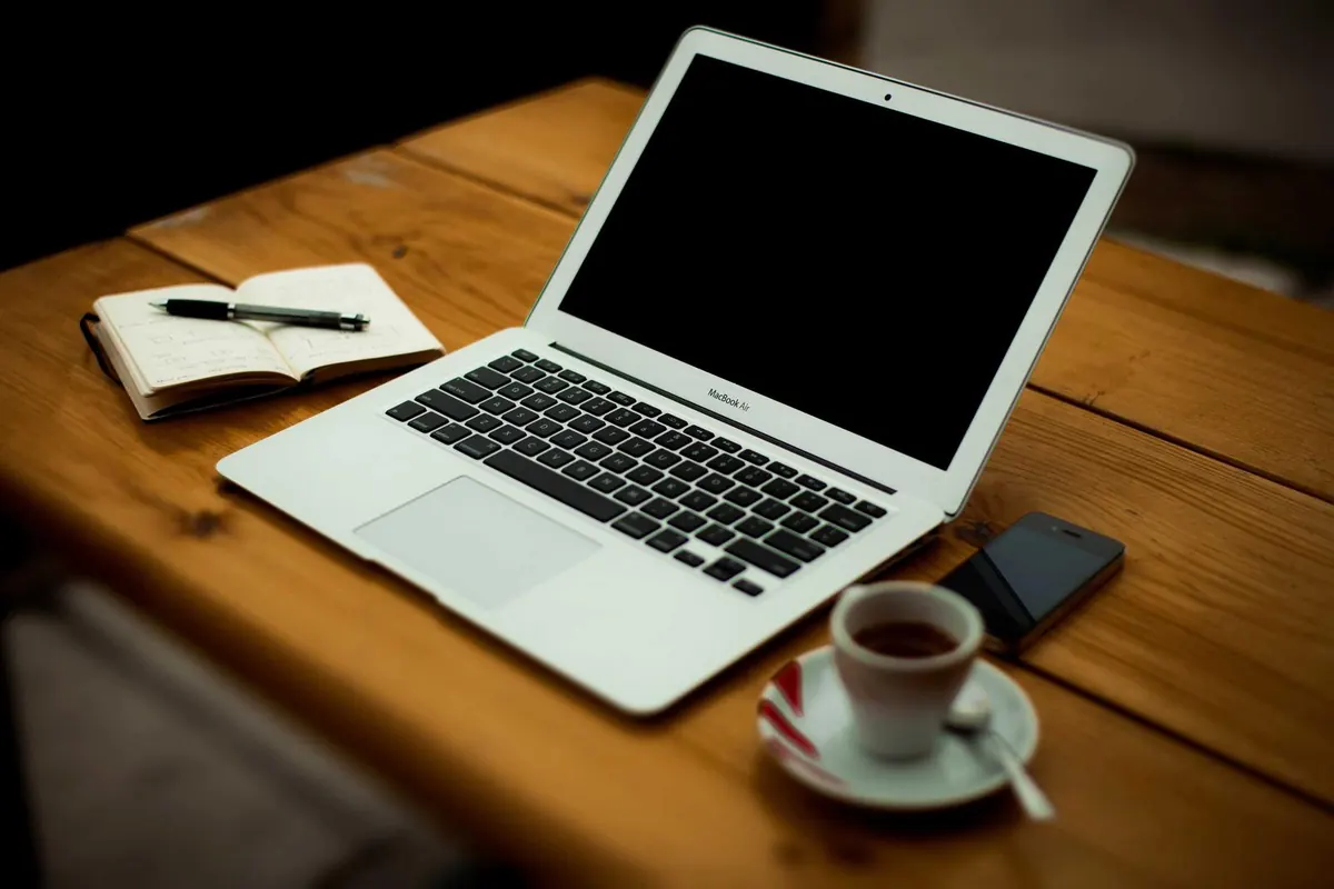 Laptop and phone on a wooden desk during a design review