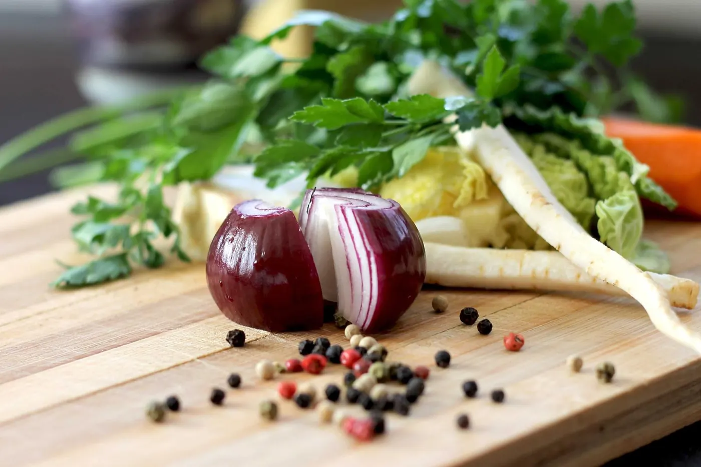 Fresh onions, herbs and peppercorns on a board