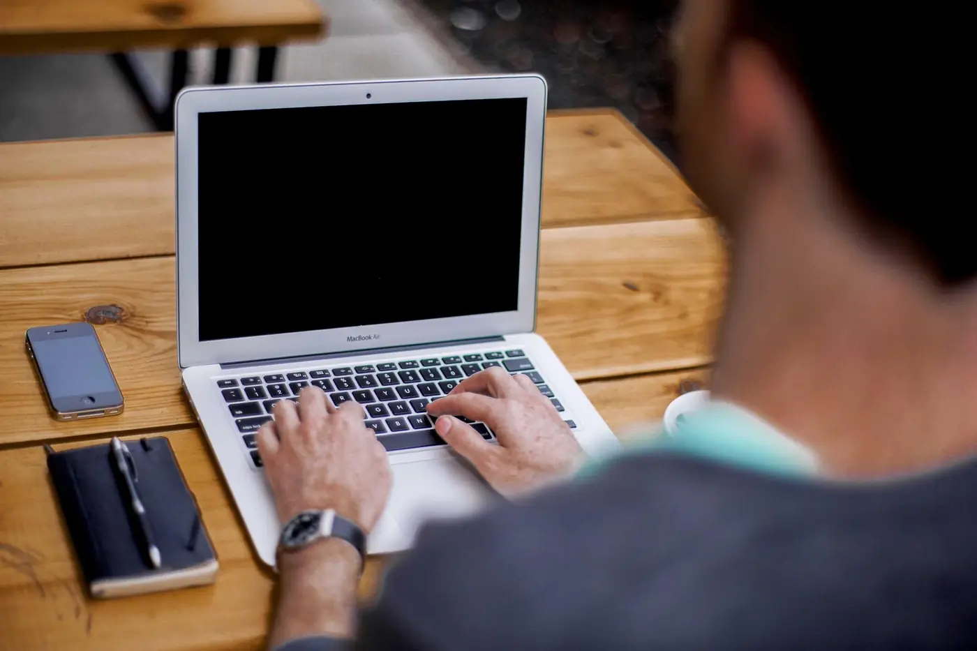 Founder working on a laptop at a café table